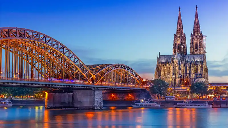 Dogan Tiefbau Hohenzollernbrücke über den Rhein mit Kölner Dom am Abend